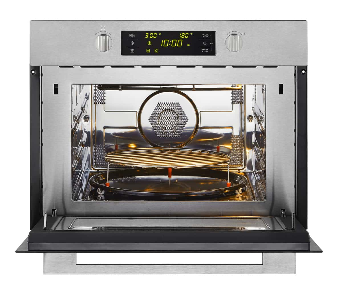 Open stainless steel microwave oven. Interior with rack and glass plate. Digital display visible.