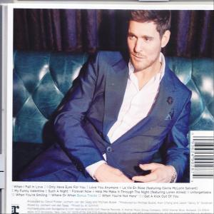 Michael Bublé auf einer Couch. Er trägt einen blauen Anzug und ein weißes Hemd.