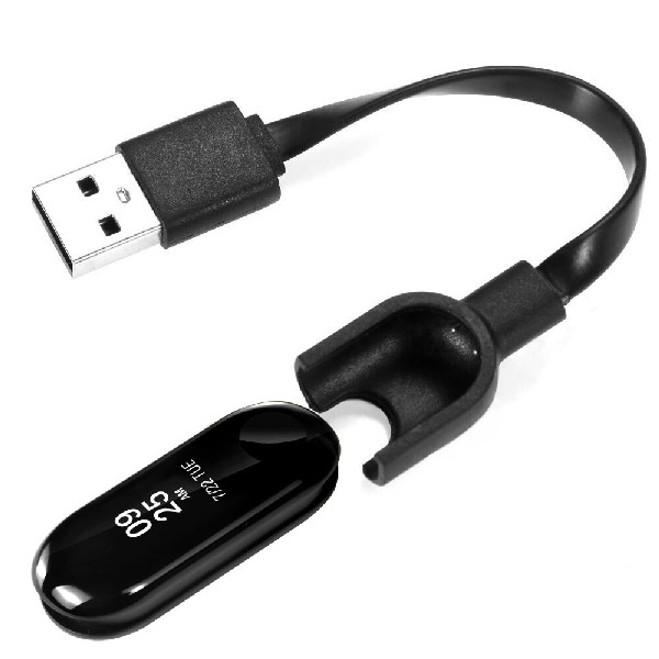 Cargador negro Mi Band 4. Tiene un enchufe USB, una base de carga y la banda. Fondo blanco.