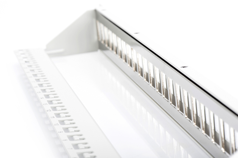 Weißes Metall-Rack-Gerät mit Schlitzen. Ein Lineal liegt daneben.