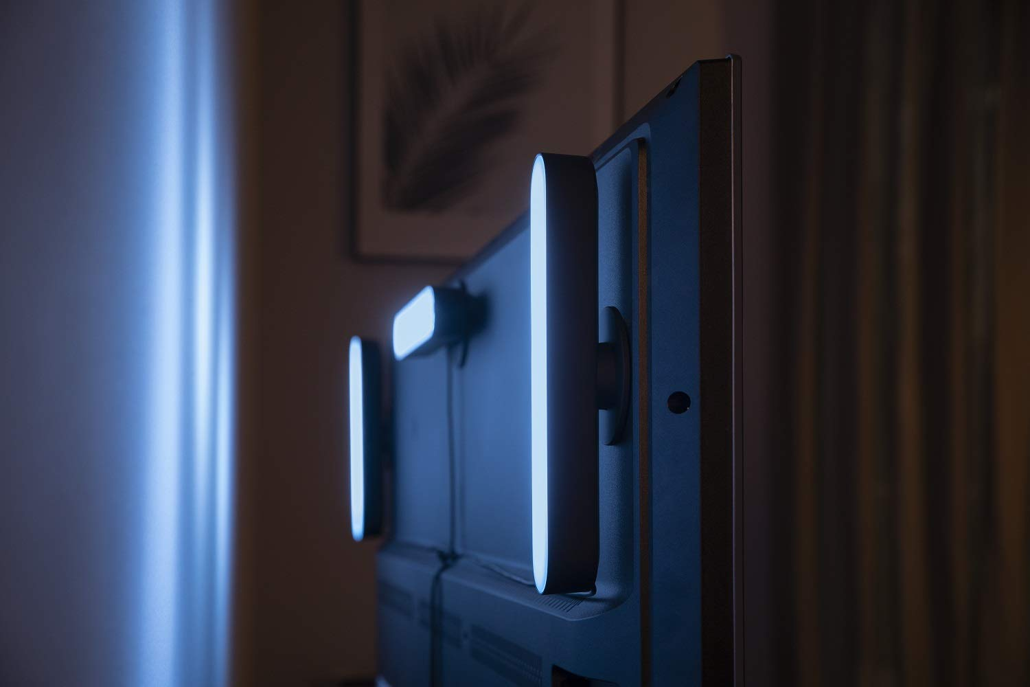 Televisor con luces LED en la parte posterior. Habitación oscura, luz azul, pintura.