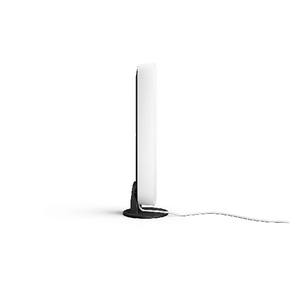 Vista lateral de un dispositivo blanco rectangular sobre un soporte negro, con cable blanco.