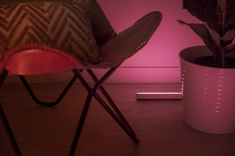 Una escena de habitación con una silla, una planta y una barra de luz.
