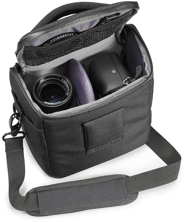 Sac photo avec un appareil photo et un objectif à l'intérieur. Le sac est ouvert. Il y a une sangle.