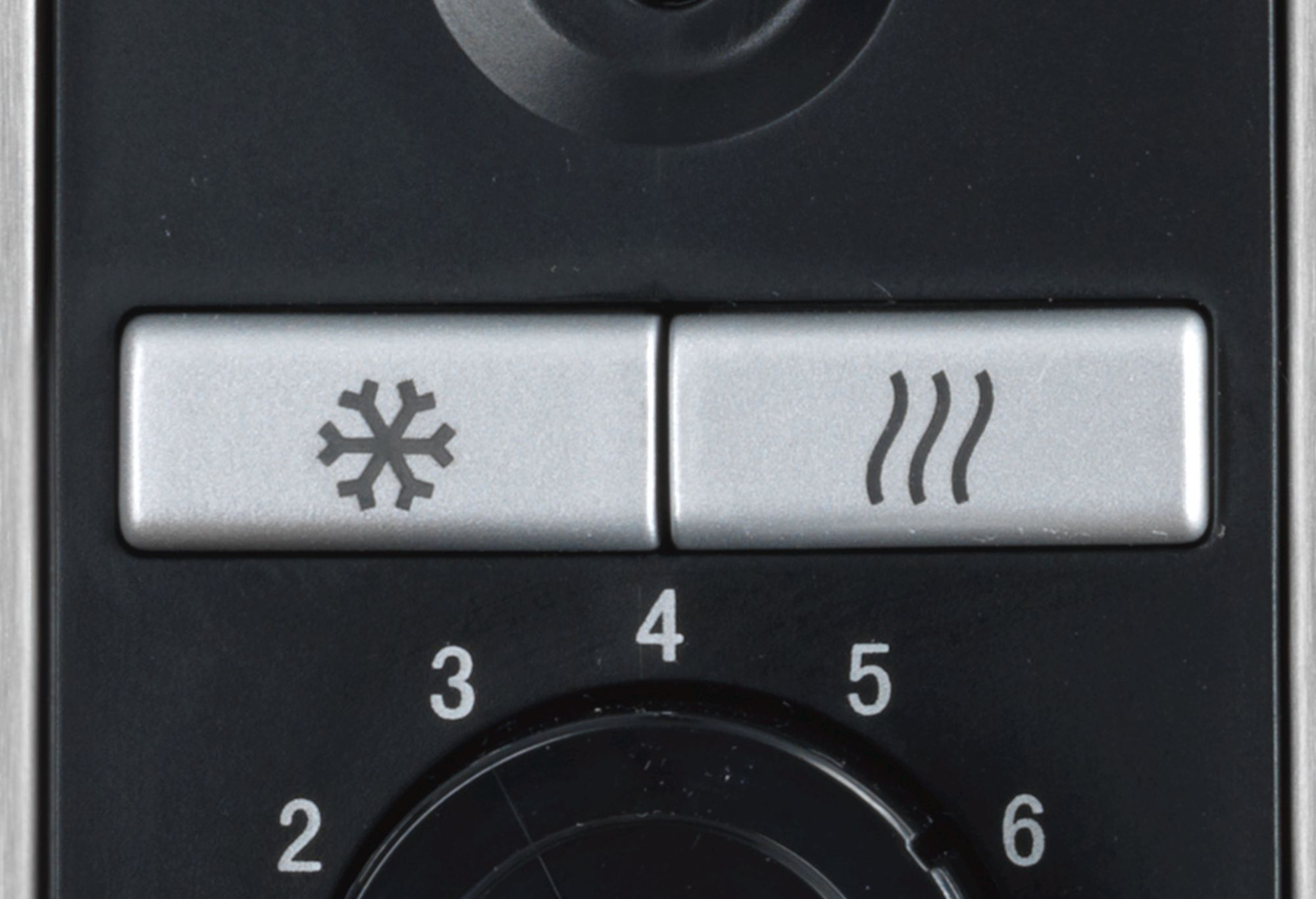 Schwarzes Backofen-Bedienfeld mit Schneeflocken- und Wellensymbolen mit Zahlen.