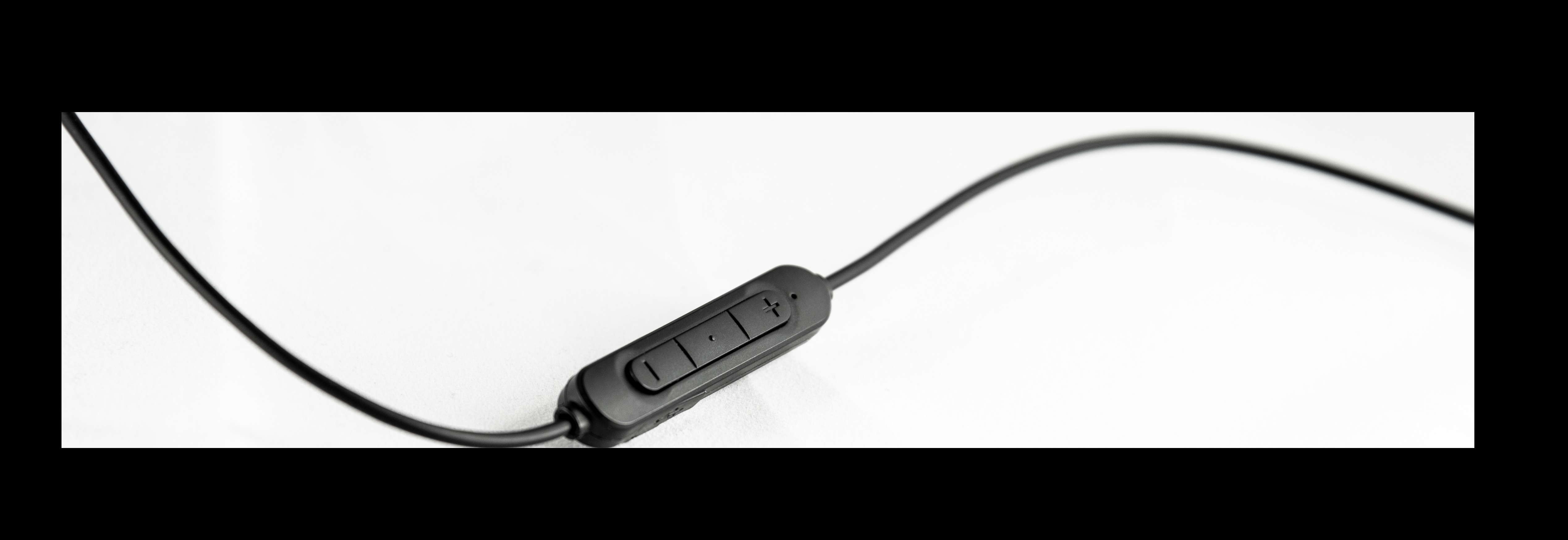 Ein schwarzes Audiokabel mit Inline-Steuerung. Die Steuerung hat drei Tasten.