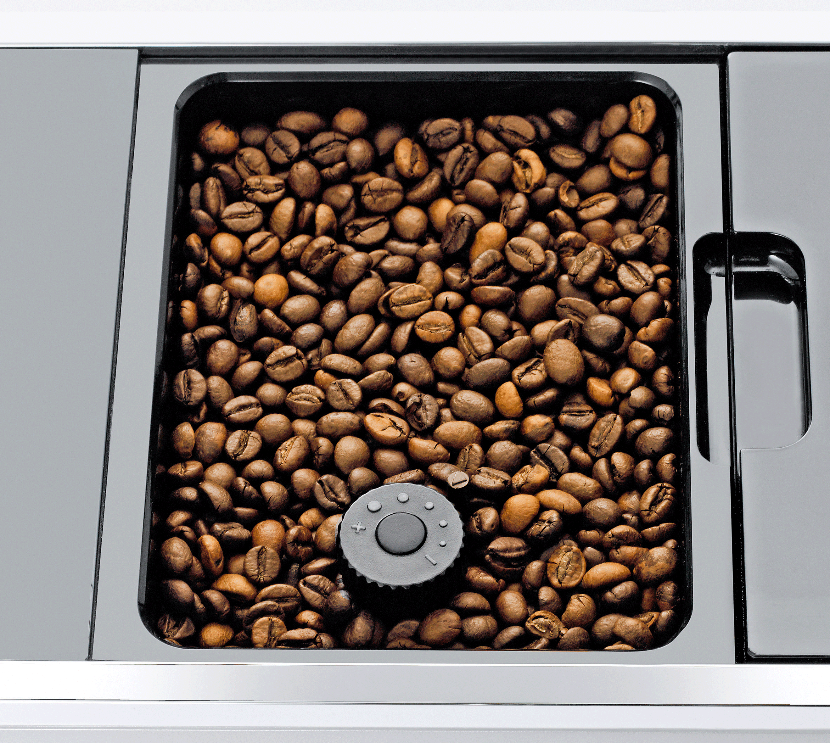 Kaffeebohnen in einem Behälter mit einem Drehknopf unten.