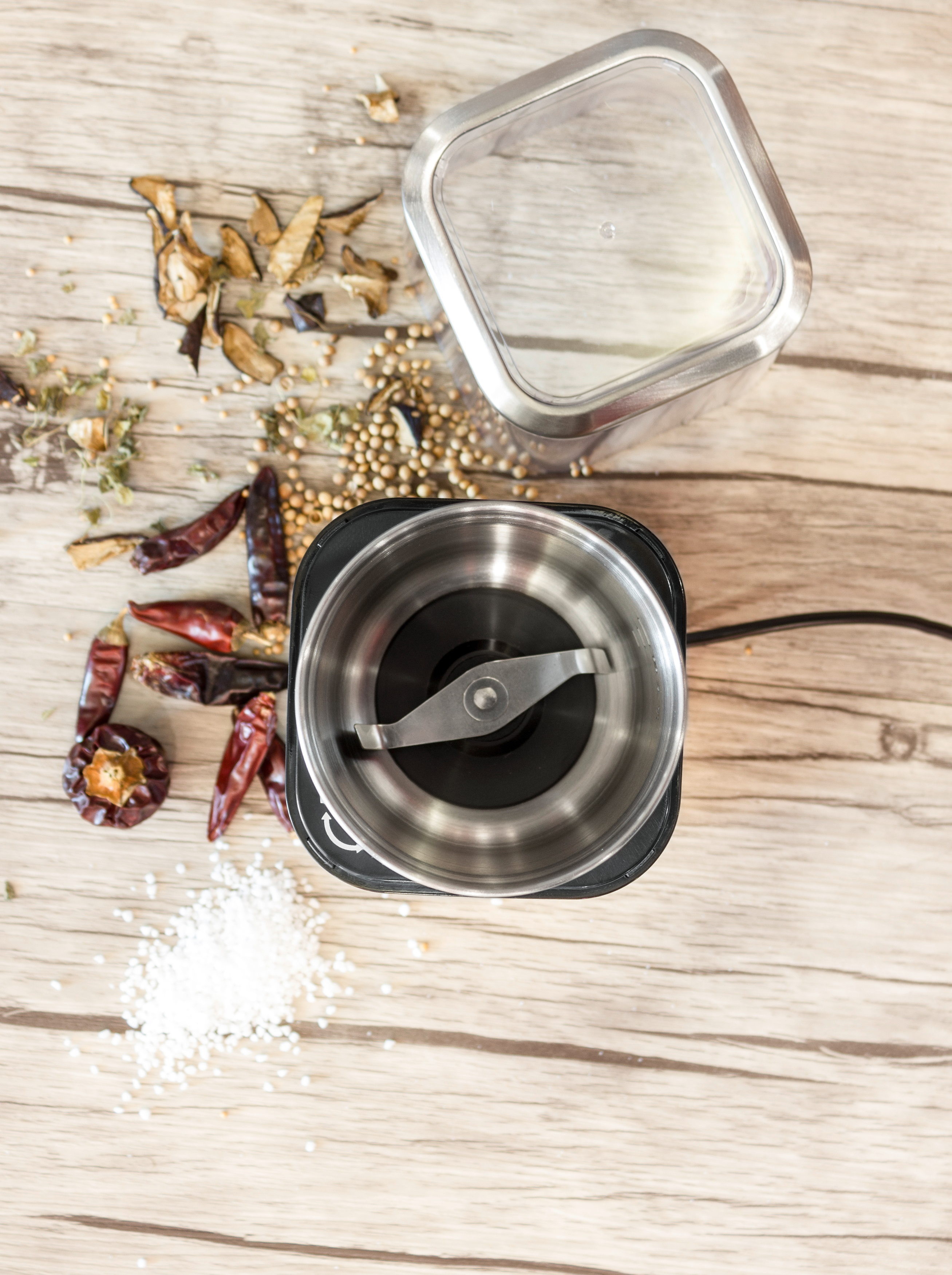 Draufsicht auf eine Gewürzmühle und Zutaten. Enthält rote Paprika, Gewürze und Salz.