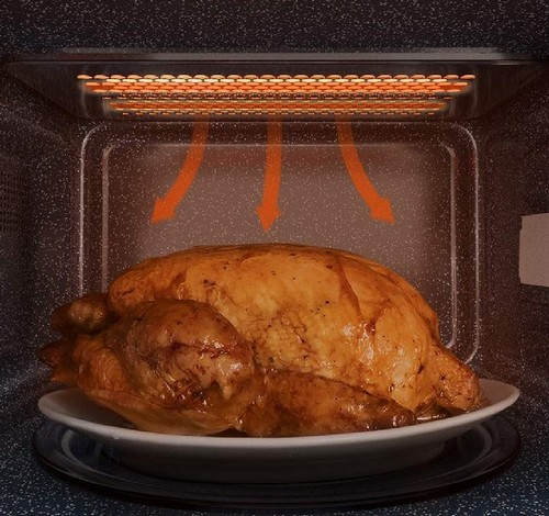 Interior de un horno microondas, con un pollo asado en un plato. Luz naranja.