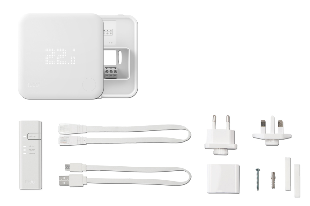 Weißer Smart-Thermostat mit Anzeige von 22,1, Kabeln, Steckern und einem kleinen Gerät. Alles auf weißem Hintergrund.