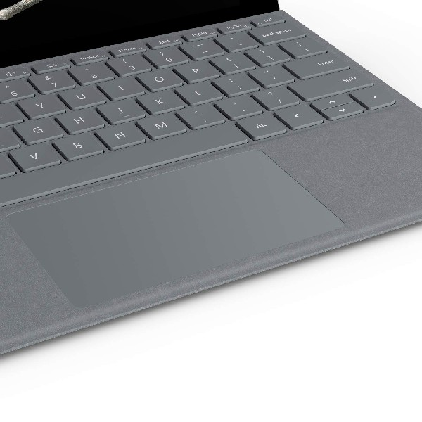 Primer plano de un teclado y panel táctil de portátil gris.