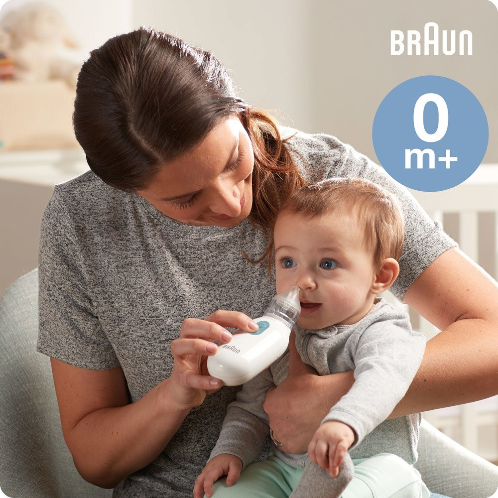 Frau, die bei einem Baby einen Braun Nasensauger benutzt. Das Baby schaut in die Kamera.