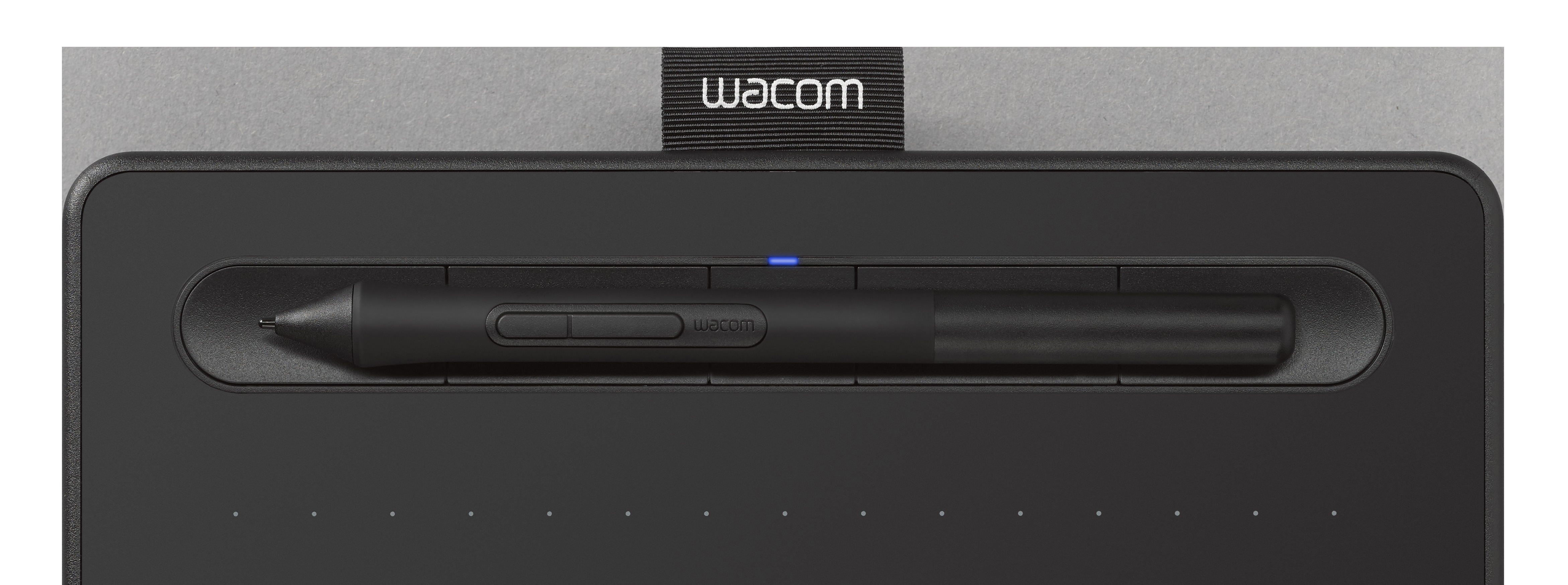 Schwarzes Wacom-Tablet mit Stift. Stift in einem Schlitz auf dem Tablet. Grauer Hintergrund.