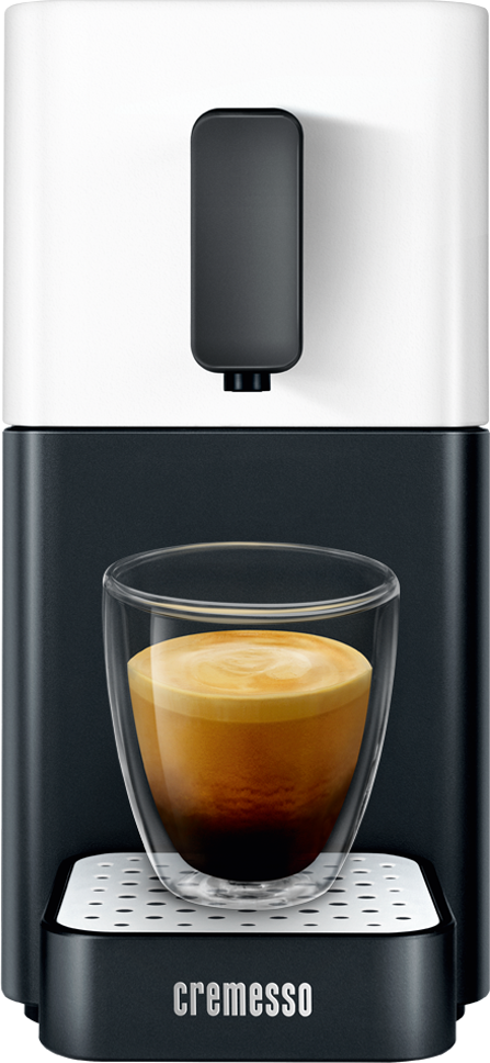 Espresszó gép egy pohár kávéval. Krémes hab a tetején.