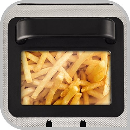 Primer plano de una freidora de aire con patatas fritas dentro. El dispositivo es plateado y negro.
