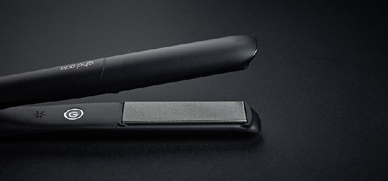 Plancha de pelo negra sobre superficie negra. Marca visible.