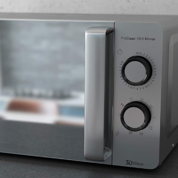 Horno microondas plateado con botones y dial, con un fondo borroso.