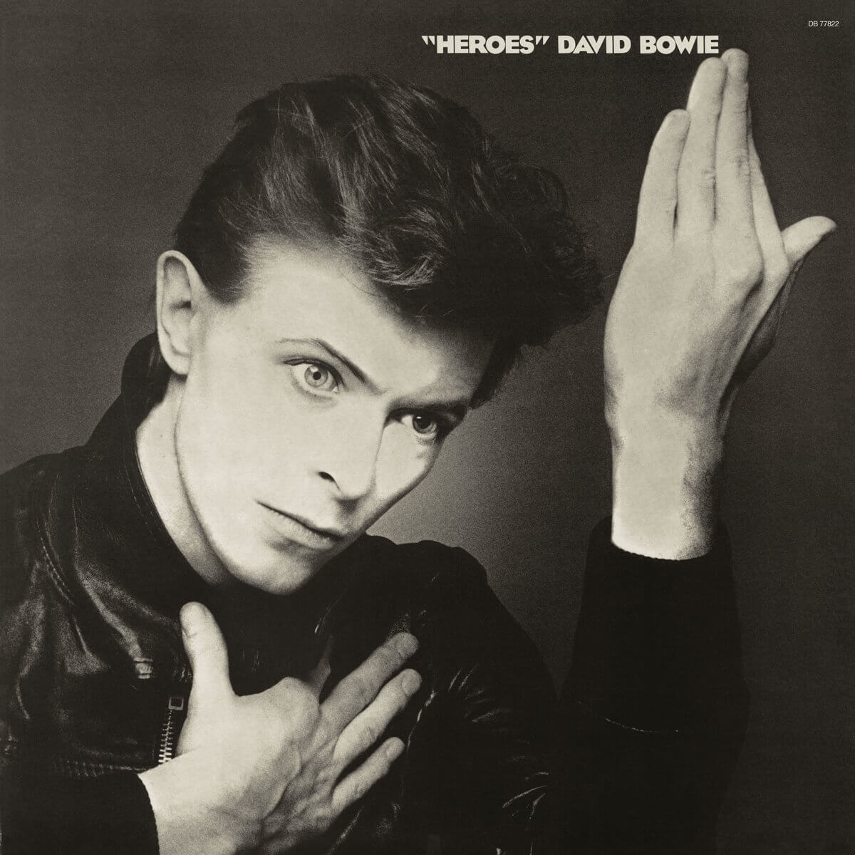 David Bowie op een zwart-wit albumhoes. Hij draagt een zwart jasje en heeft zijn hand omhoog.