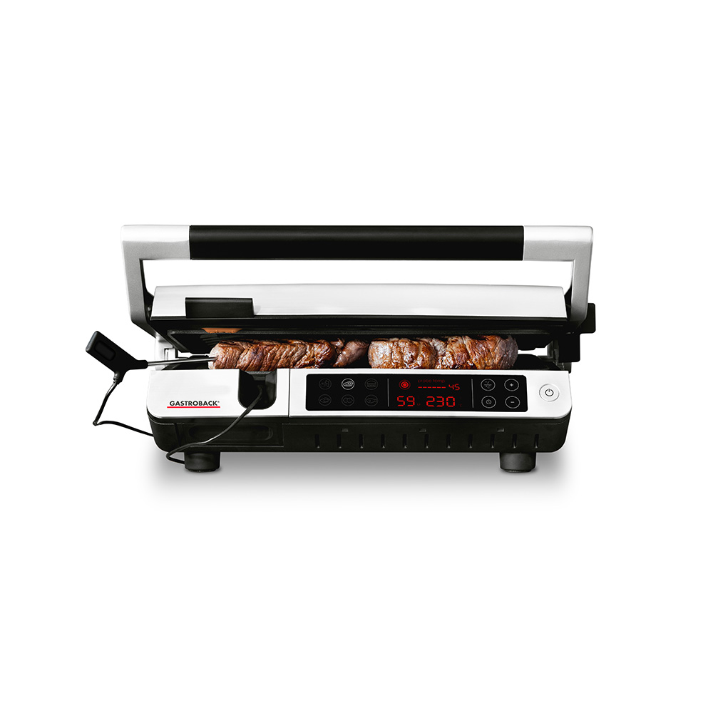 Gastroback-Grill mit gegrilltem Essen. Verfügt über ein digitales Display. Der Grill ist weiß und schwarz.