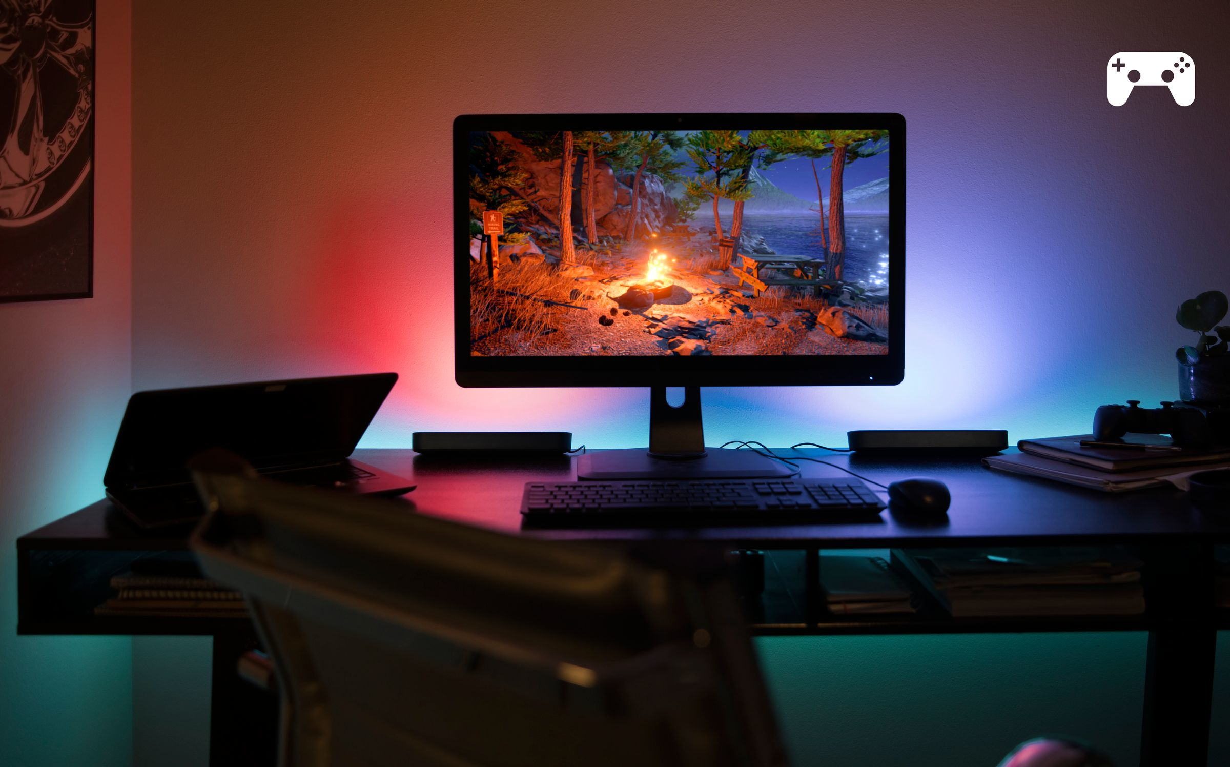 Un'impostazione di gioco con un monitor che mostra una scena di falò, con illuminazione ambientale.