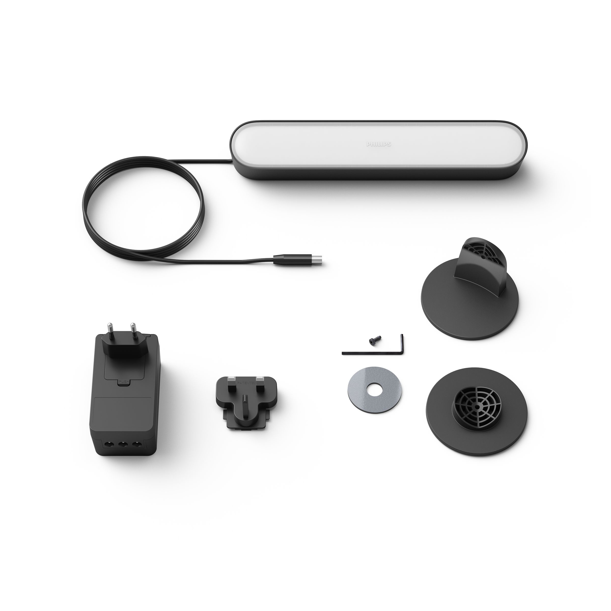 Philips Hue light bar set; light, power adapter, plugs, and mounting hardware are on a white surface.