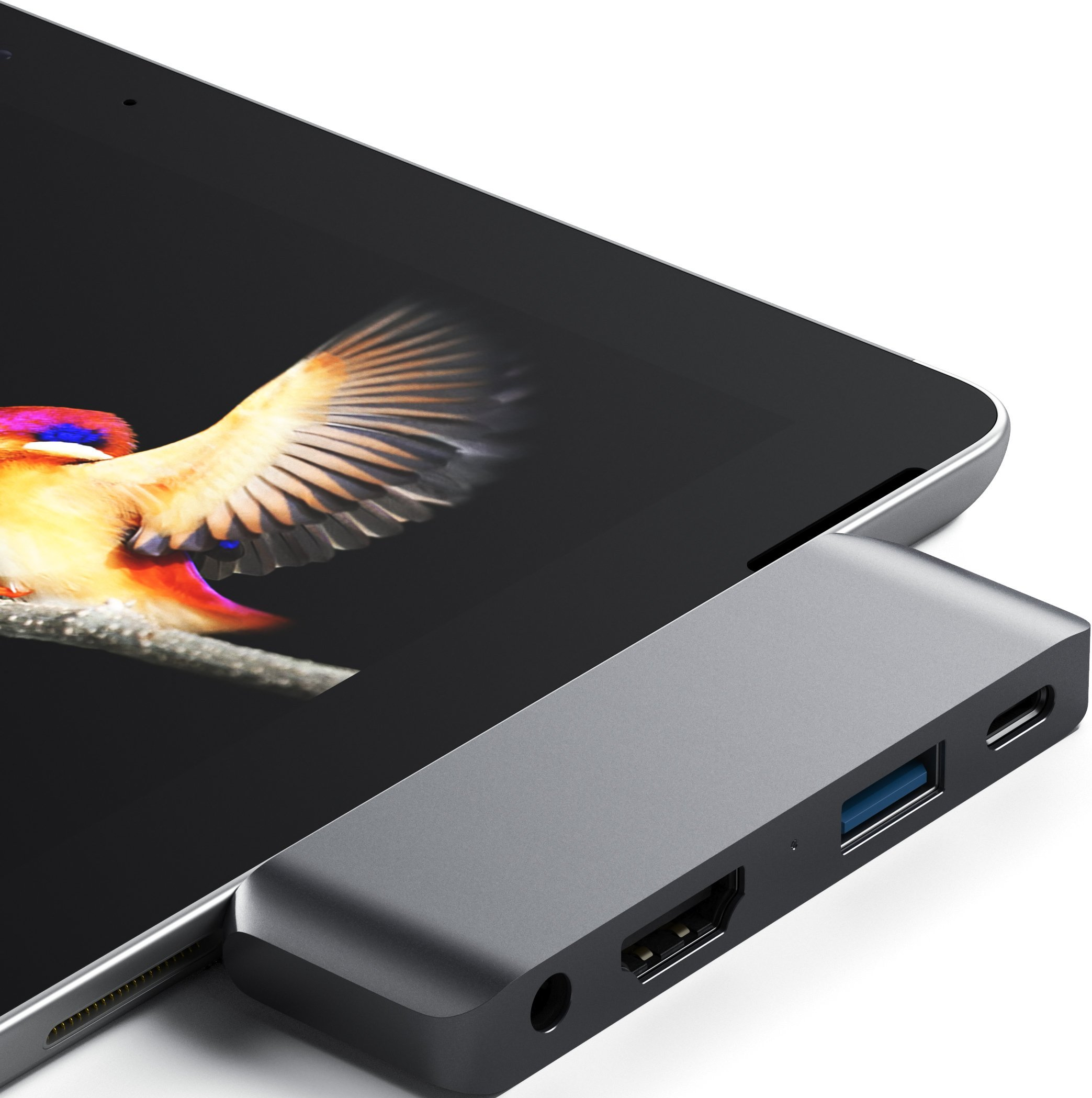 Grauer USB-C-Hub mit HDMI-, USB-A- und USB-C-Anschlüssen, an ein Tablet angeschlossen.