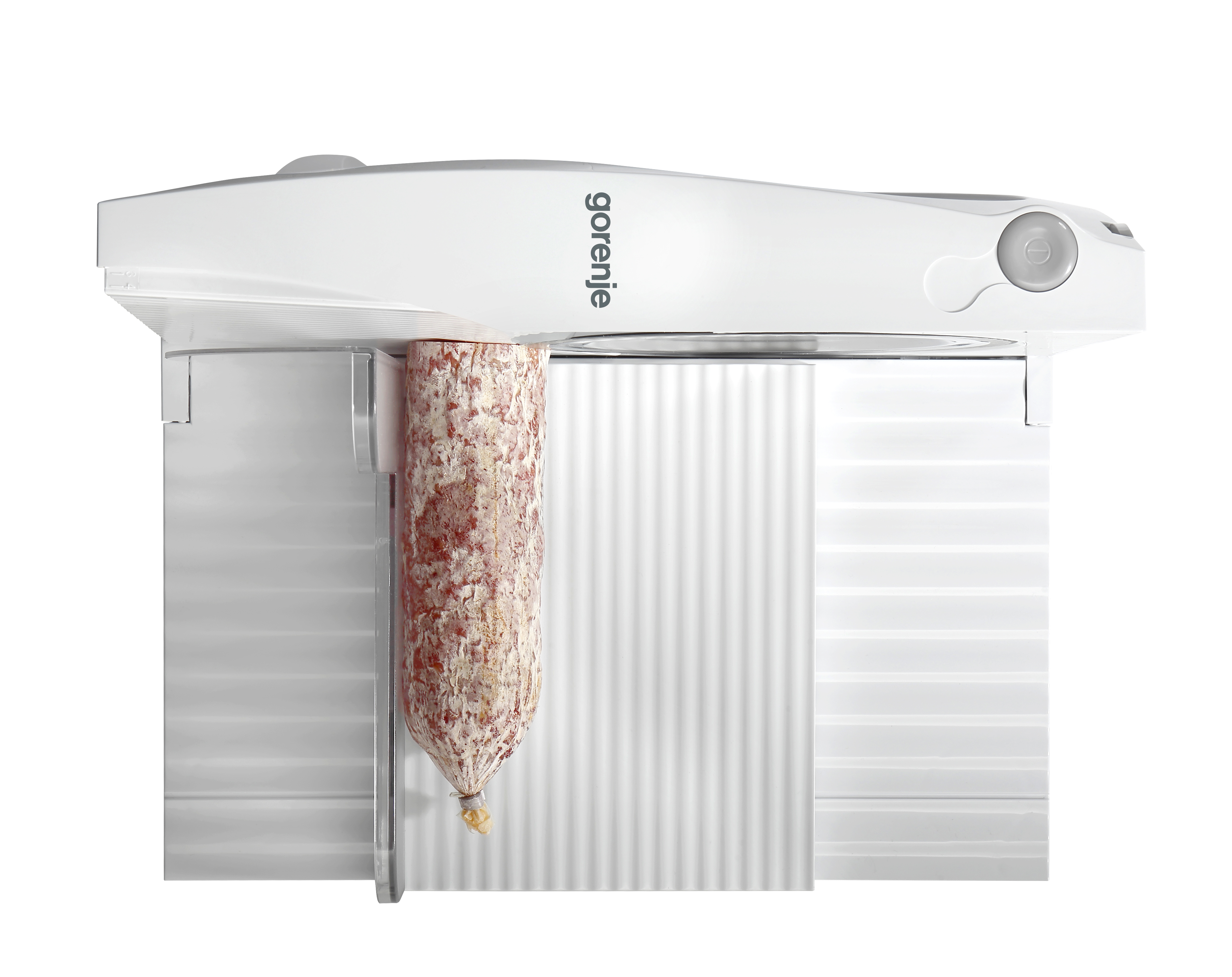 Fehér Gorenje szeletelő szalámit szeletel. A szalámi lóg. Fehér háttér.