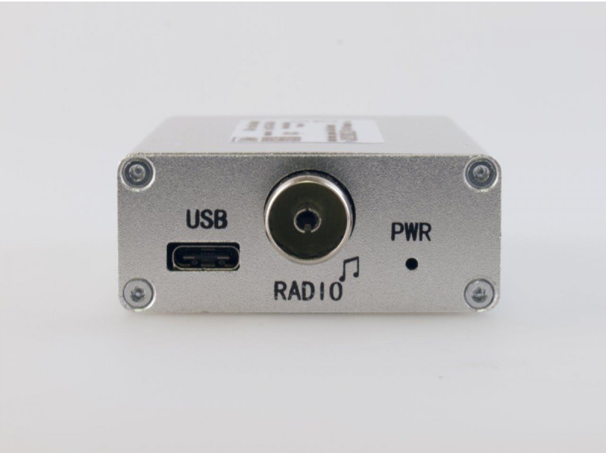 Appareil argenté avec ports USB, radio et alimentation. Il possède un symbole de note de musique et une lumière d'alimentation.