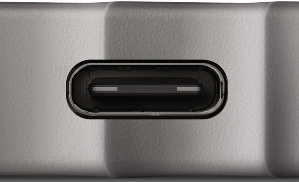 A close-up of a USB-C port, set against a silver surface.
