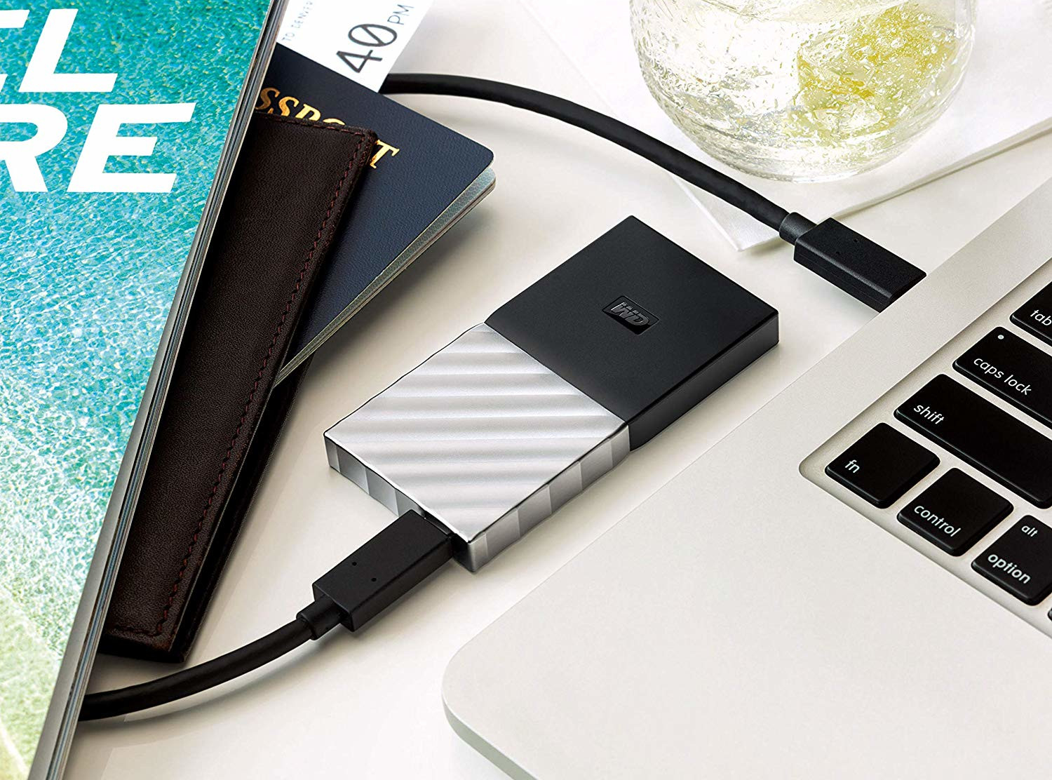 Silver and black external hard drive connected to a laptop.