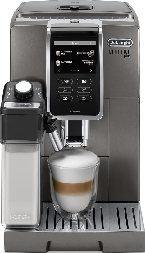 Eine DeLonghi Kaffeemaschine mit einem Milchbehälter und einem Glas Latte davor.