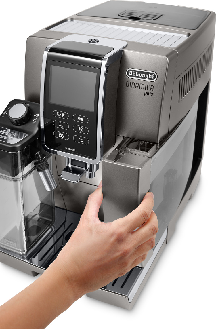 DeLonghi Dinamica Plus Kaffeemaschine, eine Hand zieht den Wassertank heraus, auf weißem Hintergrund.