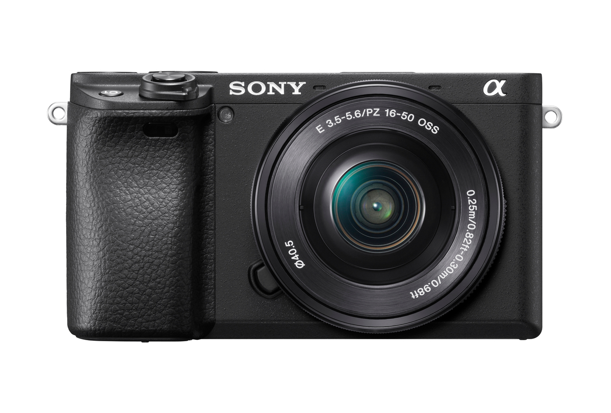 Eine schwarze Sony-Kamera, Vorderansicht, mit Objektiv und Objektivring. Das Sony-Logo ist sichtbar.