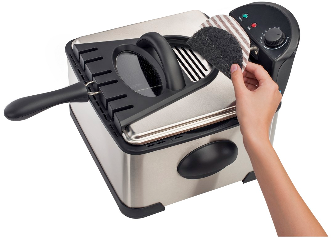 Une friteuse argentée et noire avec une main ajustant un filtre.