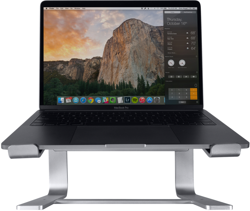 Ordinateur portable sur un support argenté, affichant un bureau avec fond montagneux.