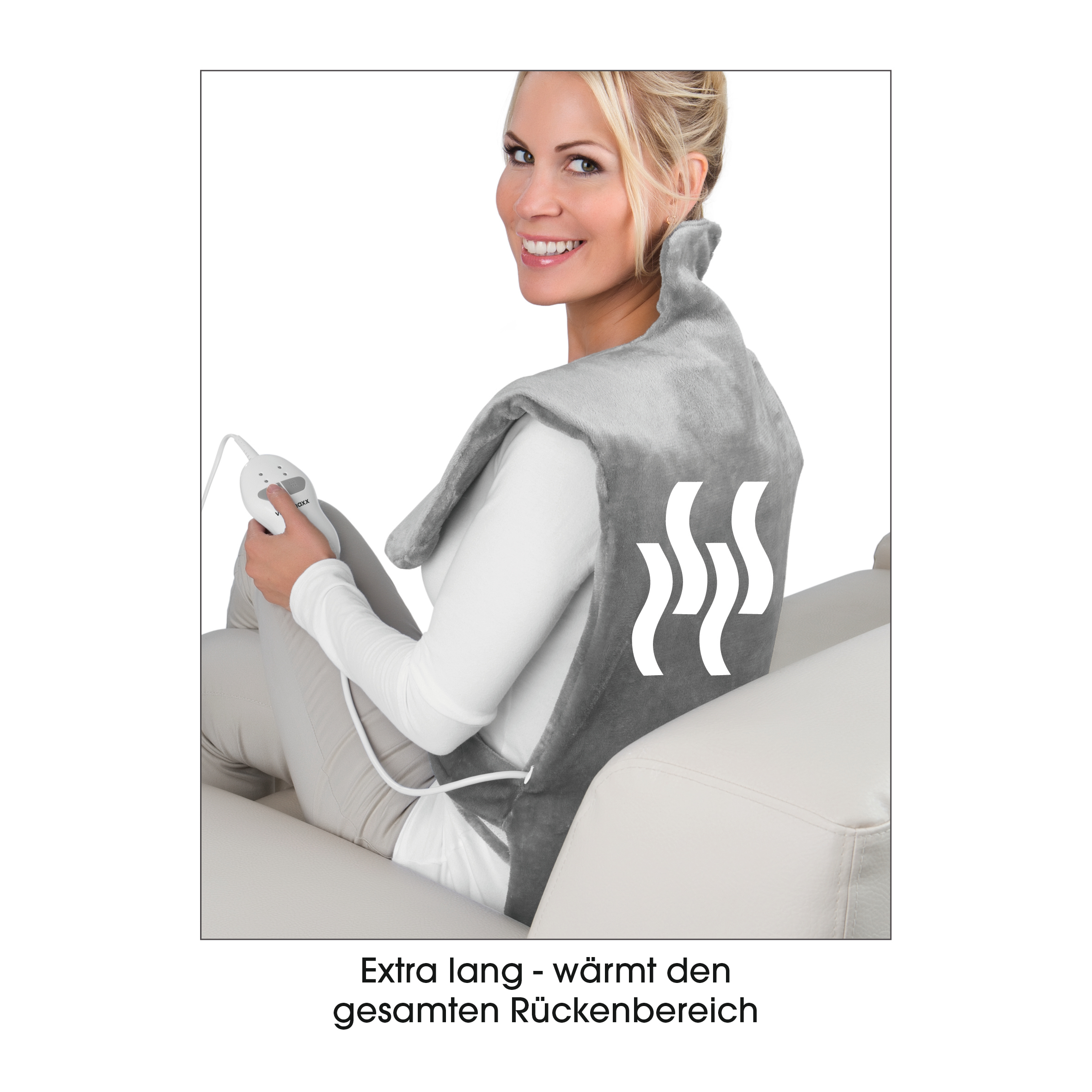 Frau mit einem grauen Heizkissen auf dem Rücken, sitzt auf einem Sofa.