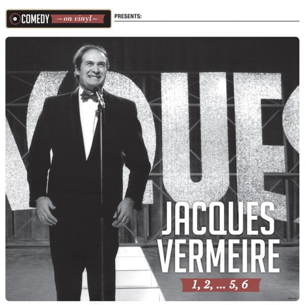 Albumhoes: Jacques Vermeire op het podium met een microfoon. Zwart pak en vlinderdas. Grote 'VOUS'-tekst.