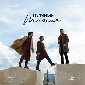 Drei Männer auf einem Felsen, mit dem Text 'IL VOLO Musica' darüber, vor einem Himmelshintergrund.