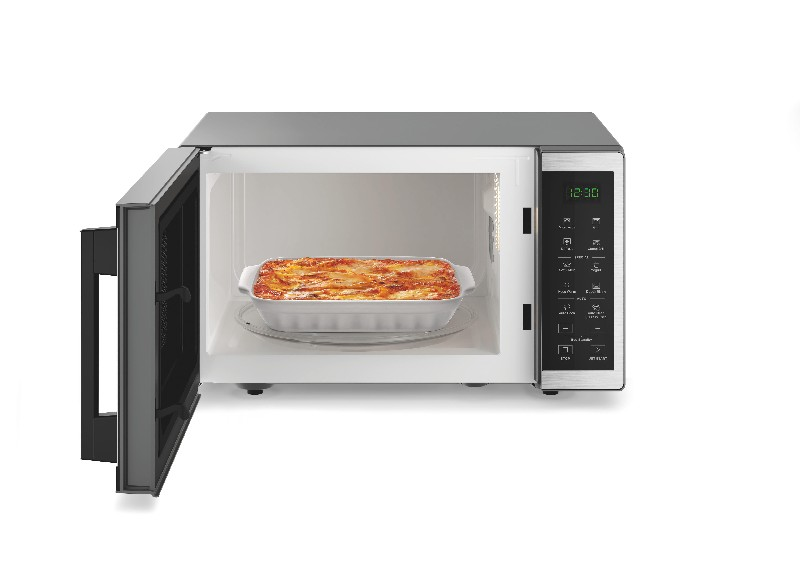 Microondas con la puerta abierta mostrando un plato de lasaña.