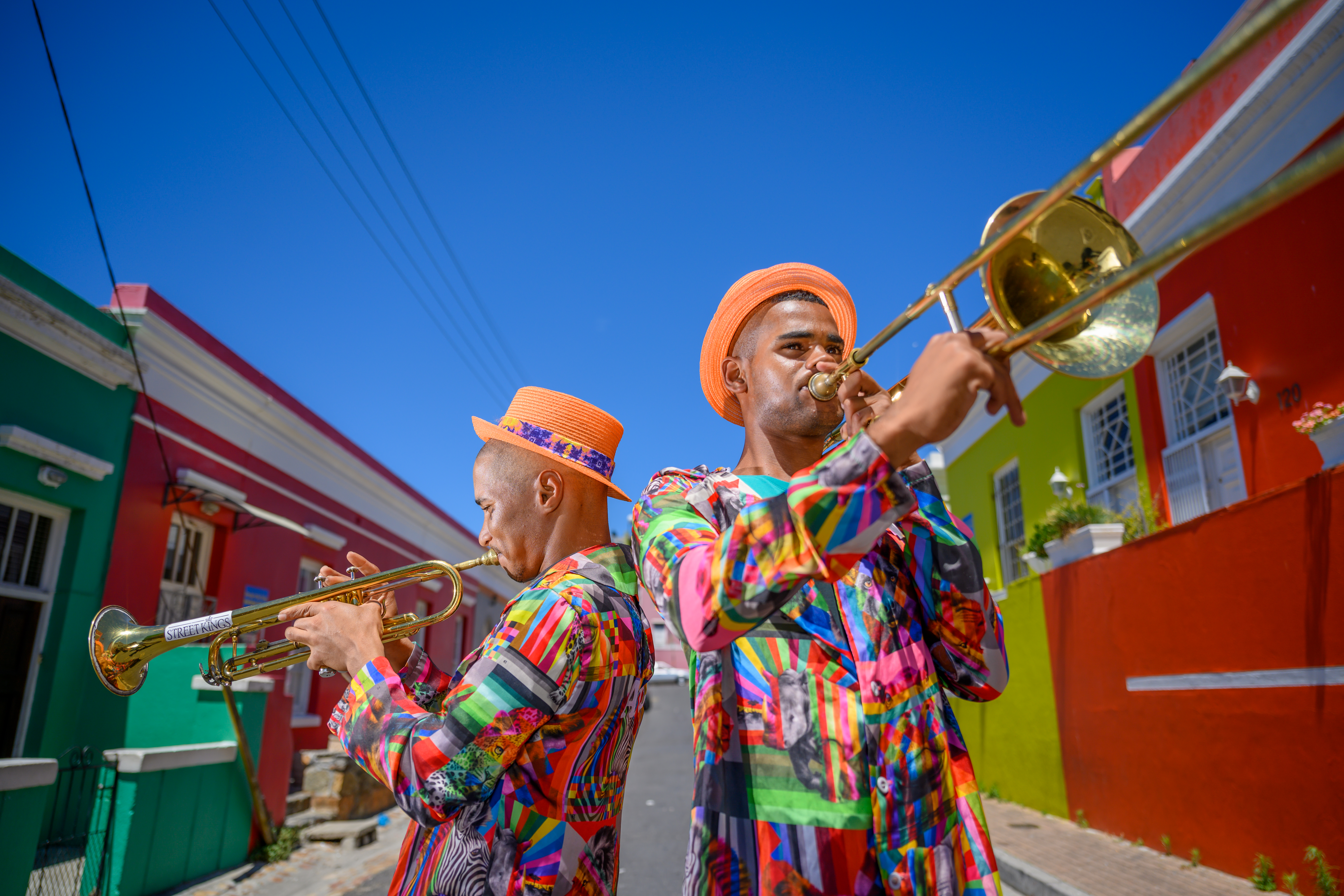 Deux hommes en vêtements colorés jouant de la trompette et du trombone.
