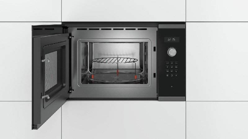 Horno microondas abierto, interior de acero inoxidable.