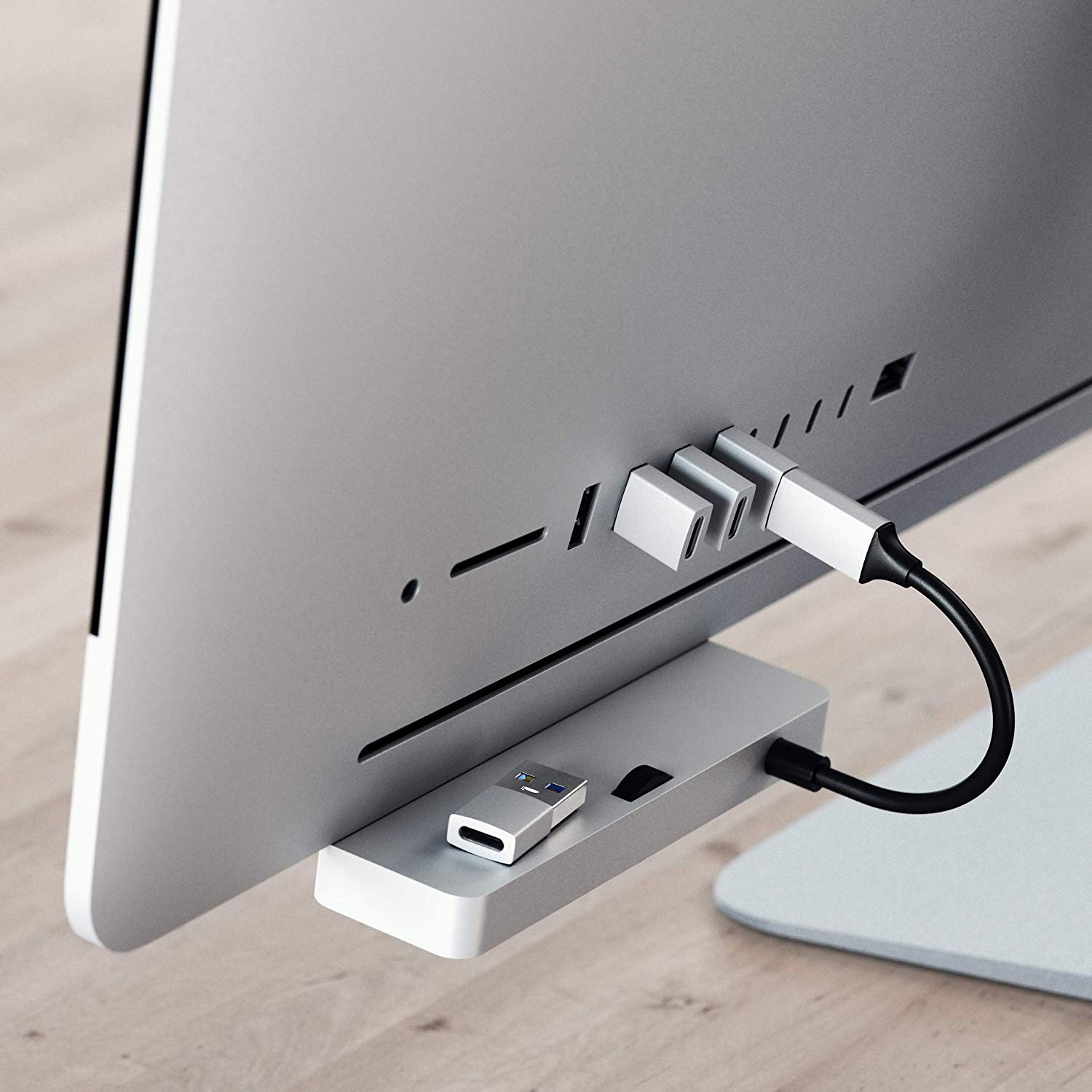 Ein silberner Hub, der über USB-Anschlüsse mit einem Monitor verbunden ist.