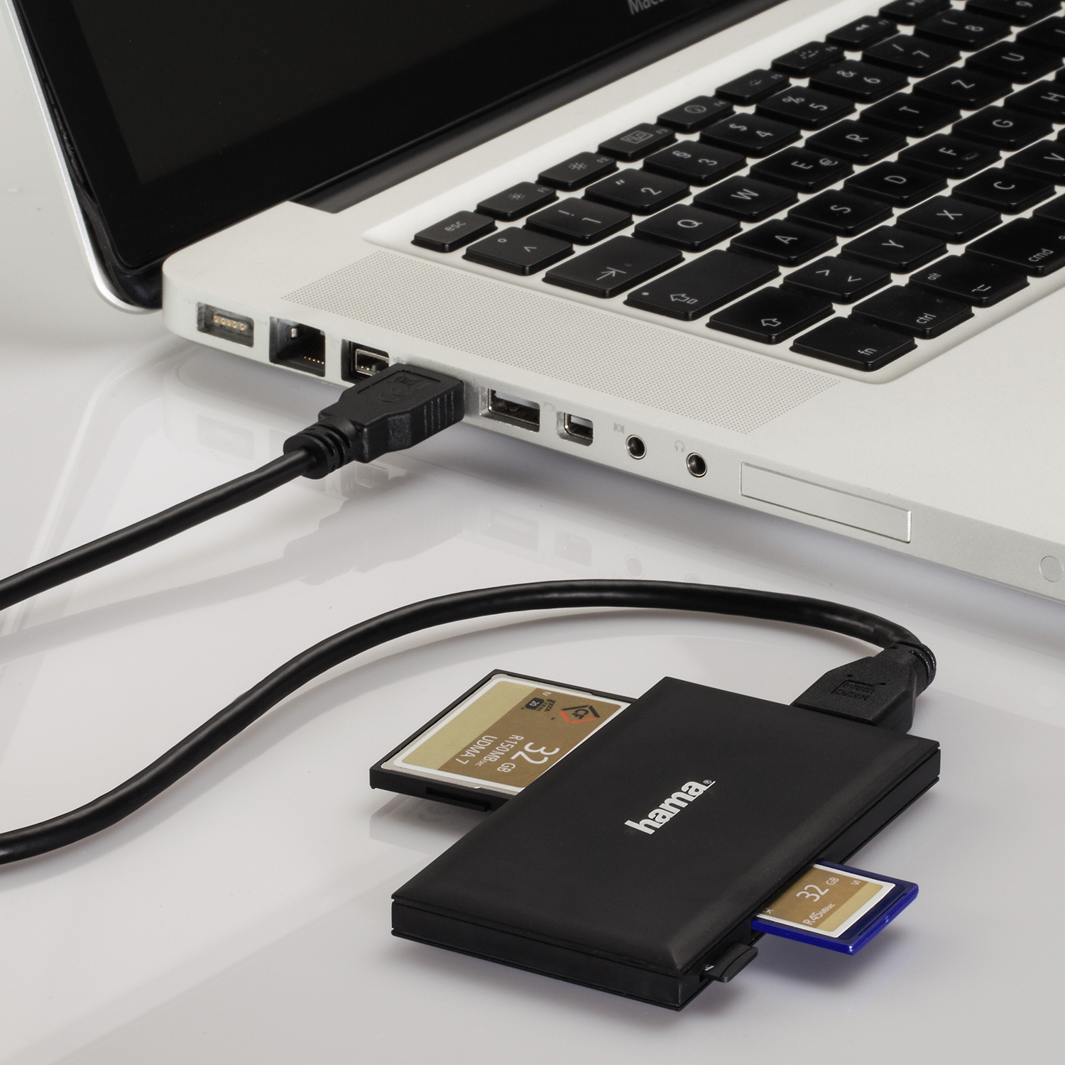 A laptop connected to a black card reader with two inserted SD cards.