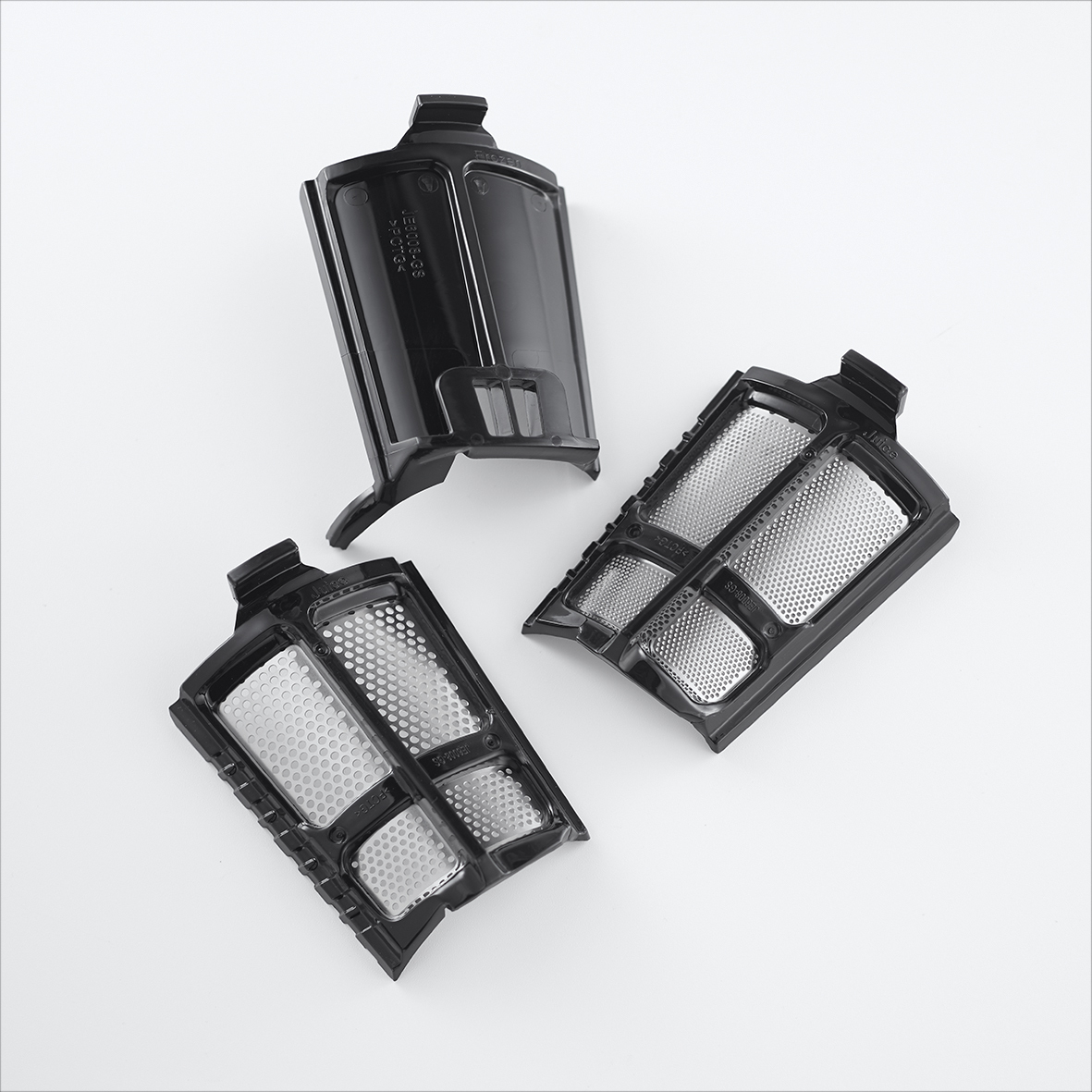 Trois filtres d'aspirateur noirs sur fond blanc. Les filtres ont un design en maille.