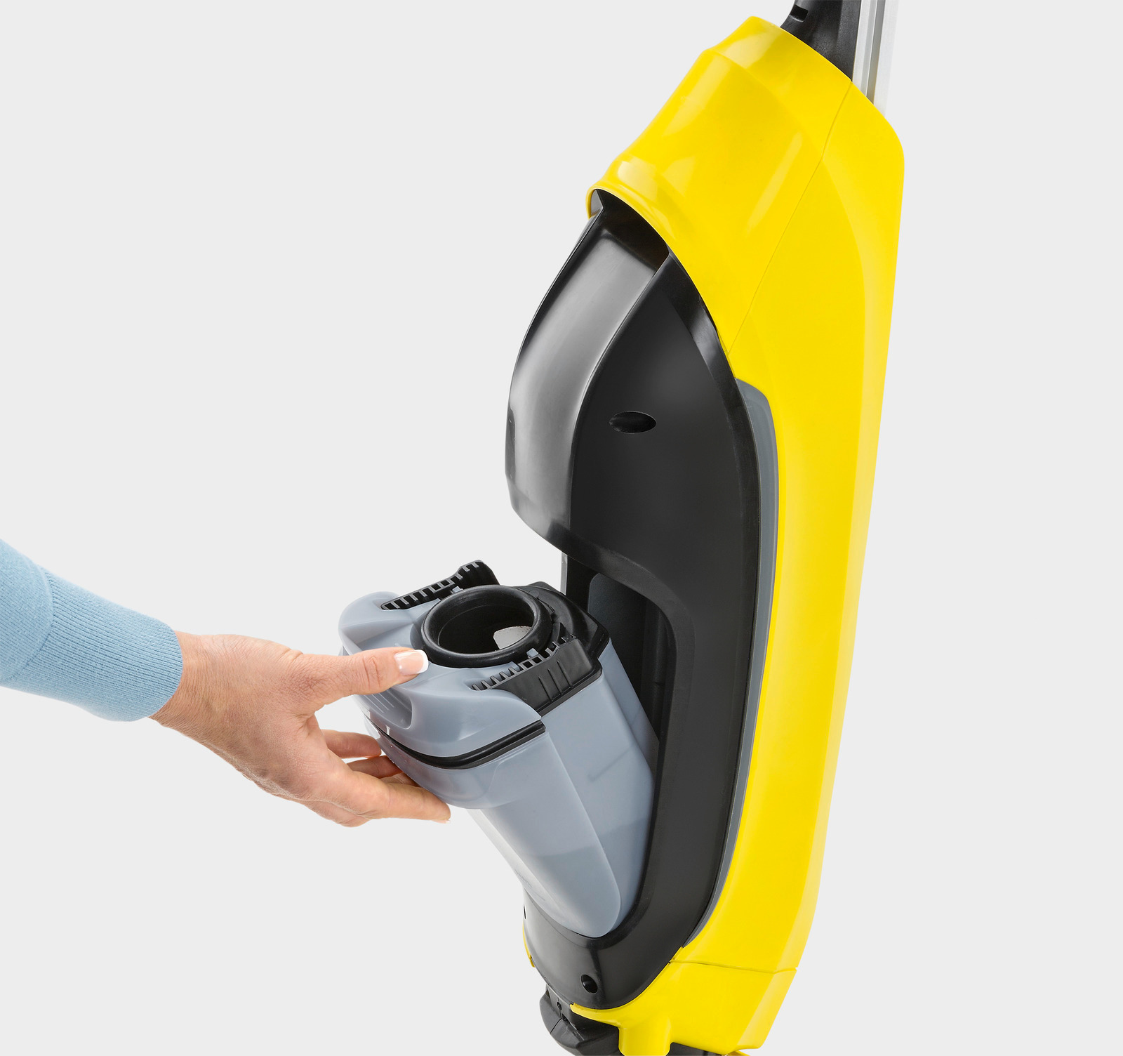 Die Hand einer Person, die einen grauen Wasserbehälter von einem gelb-schwarzen Reinigungsgerät hält.