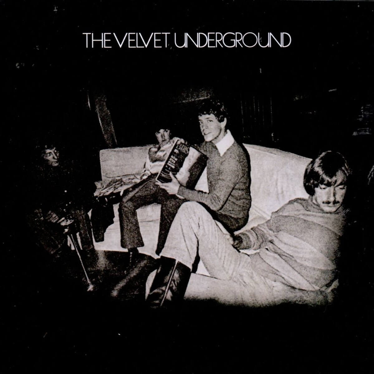 The Velvet Underground albumhoes. Band in een donkere kamer, zittend op een bank. Zwart-wit.