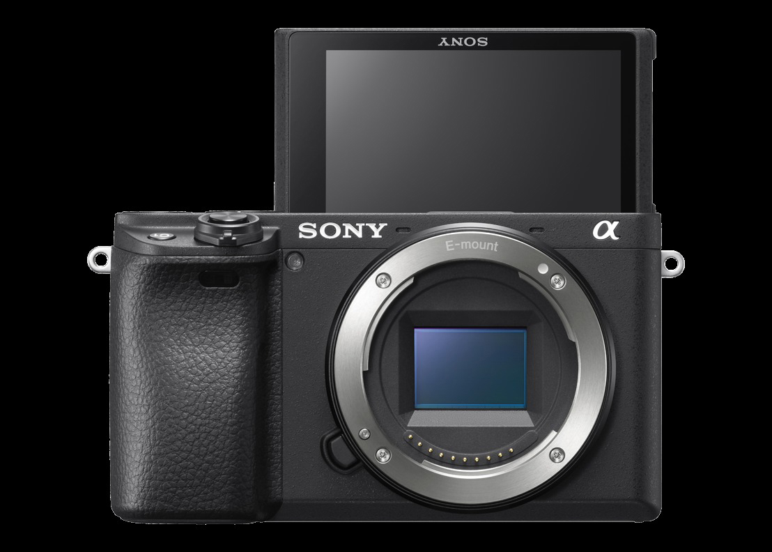Eine schwarze Sony-Kamera mit ausklappbarem Bildschirm. Das Objektiv ist sichtbar. Der Hintergrund ist dunkel.