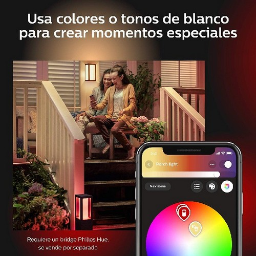 Dos mujeres en un porche usando un teléfono con una aplicación de casa inteligente, con luces al fondo.