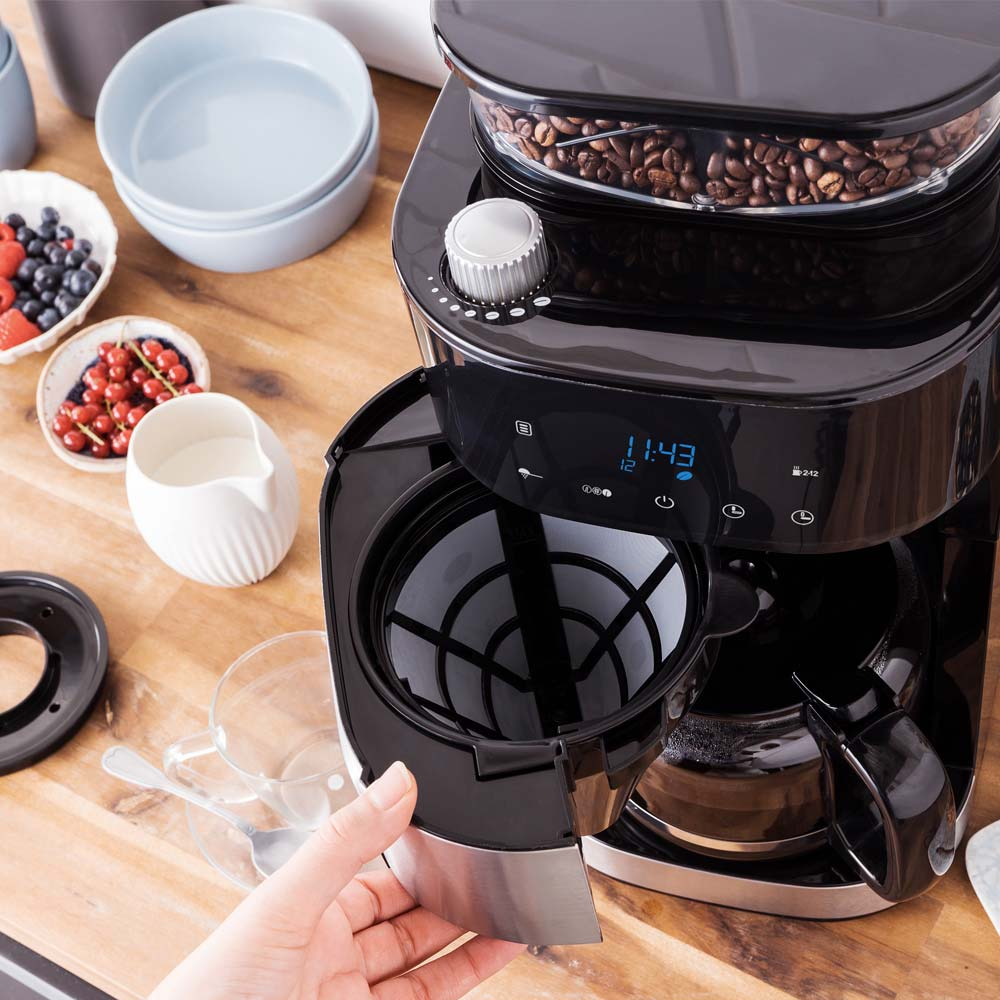 Eine Kaffeemaschine mit vollem Bohnenbehälter und Glaskaraffe.