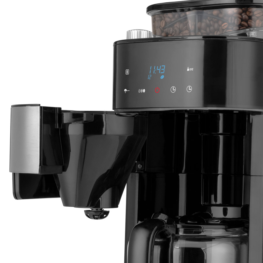 Eine Kaffeemaschine mit einem Bildschirm, der die Zeit anzeigt. Darunter eine Karaffe.